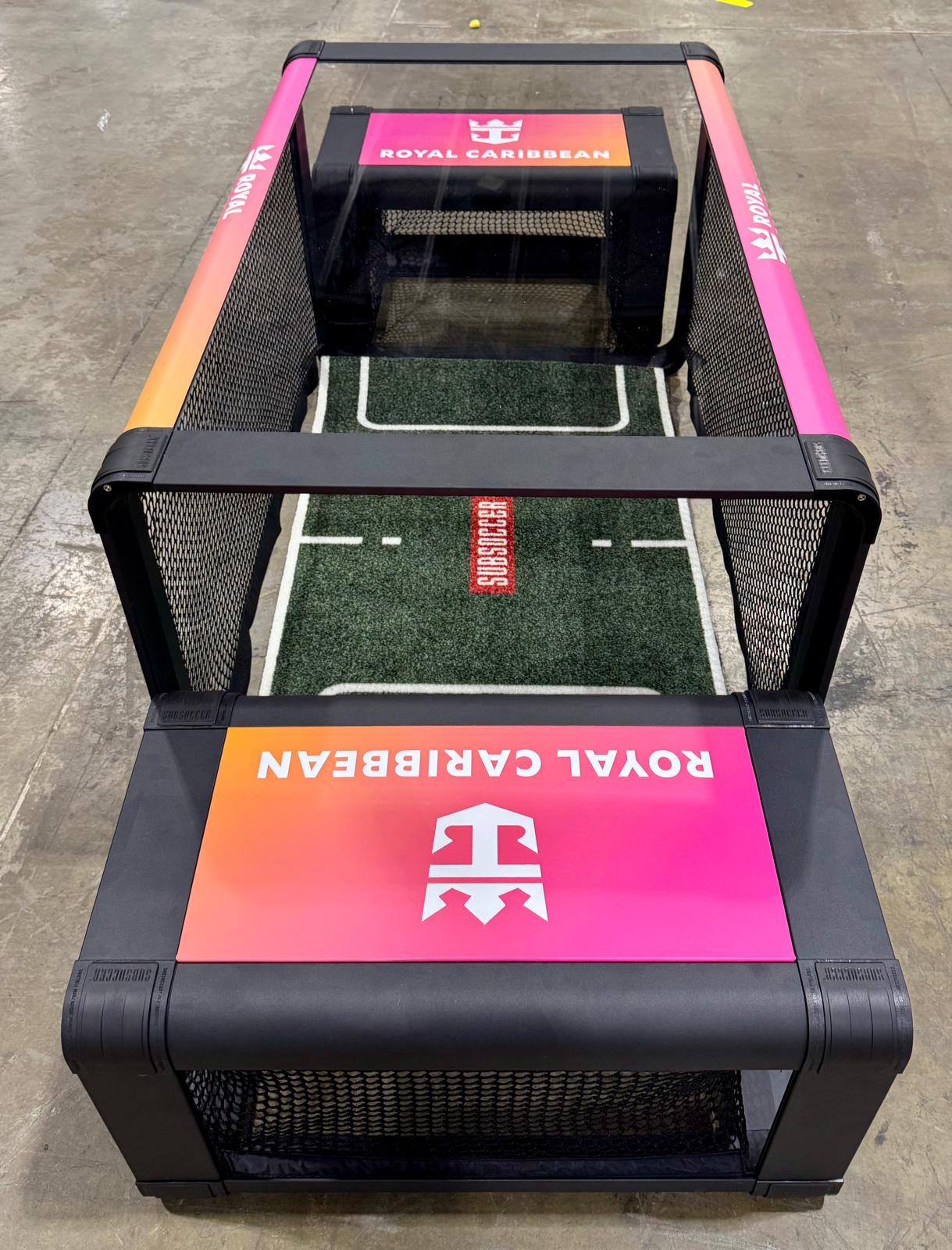 Custom branded SubSoccer table soccer game featuring the Royal Caribbean logo and sunset gradient design for cruise ship entertainment.